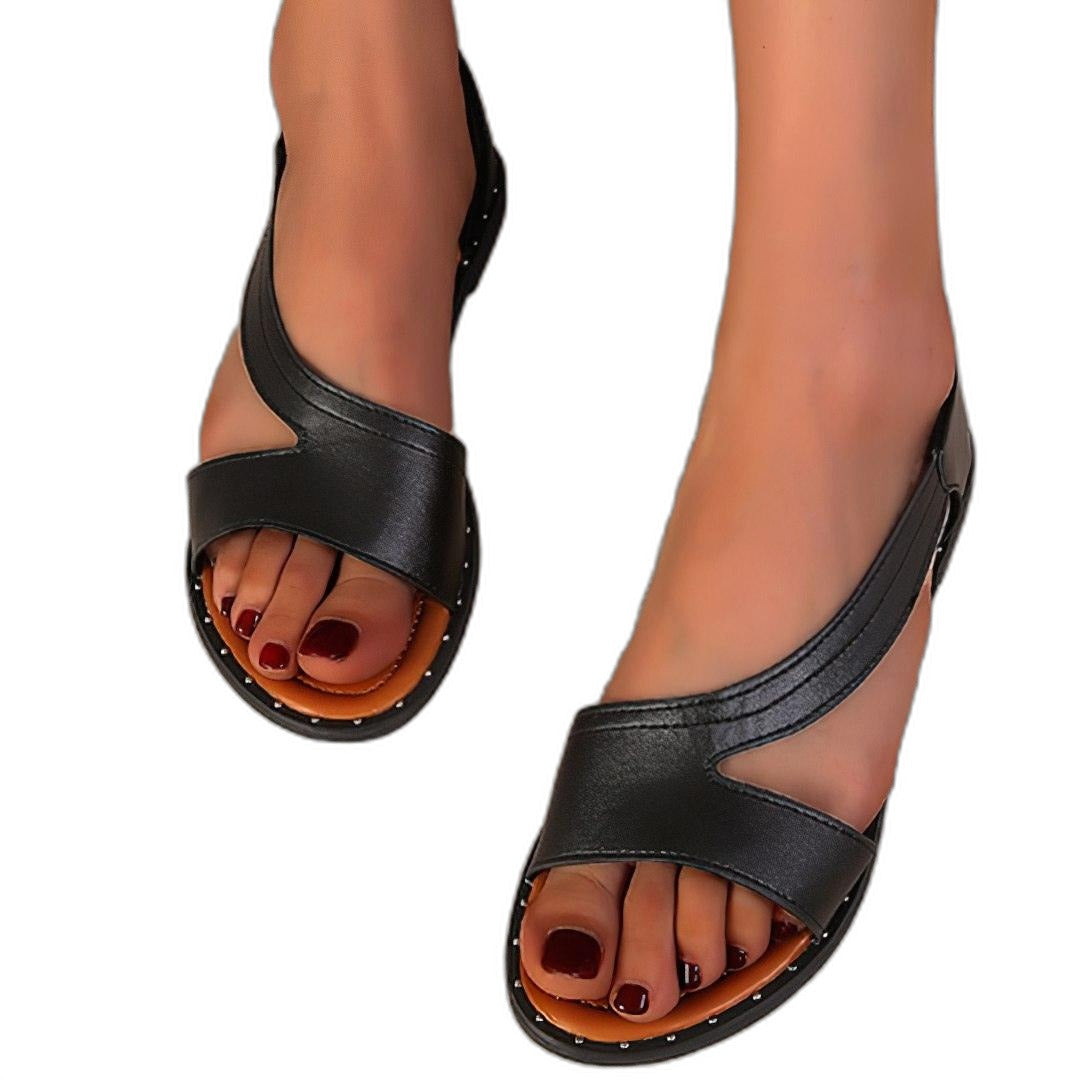 Flache Sandalen mit offener Spitze und geschlossener Ferse vor weißem Hintergrund