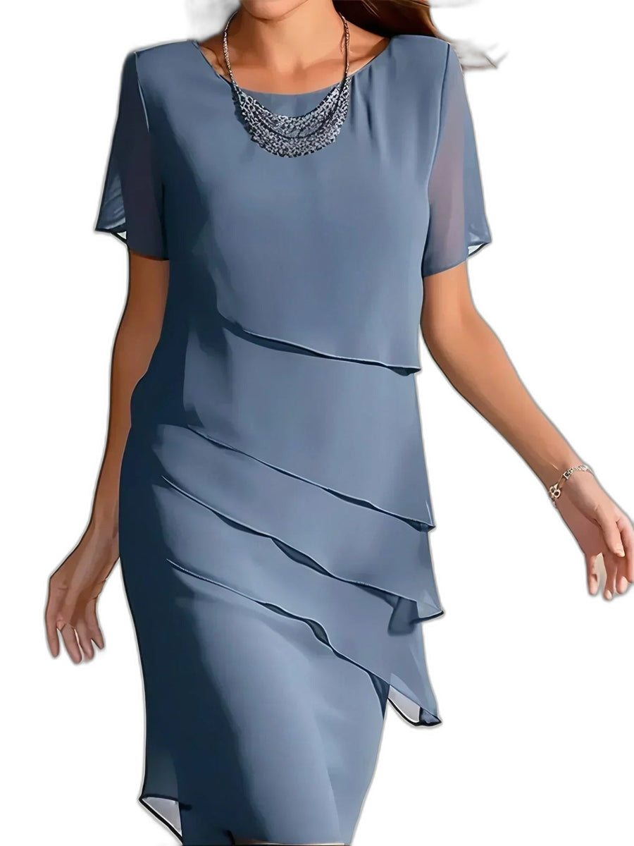Midikleid mit Stufenvolants und tailliertem Schnitt vor weißem Hintergrund